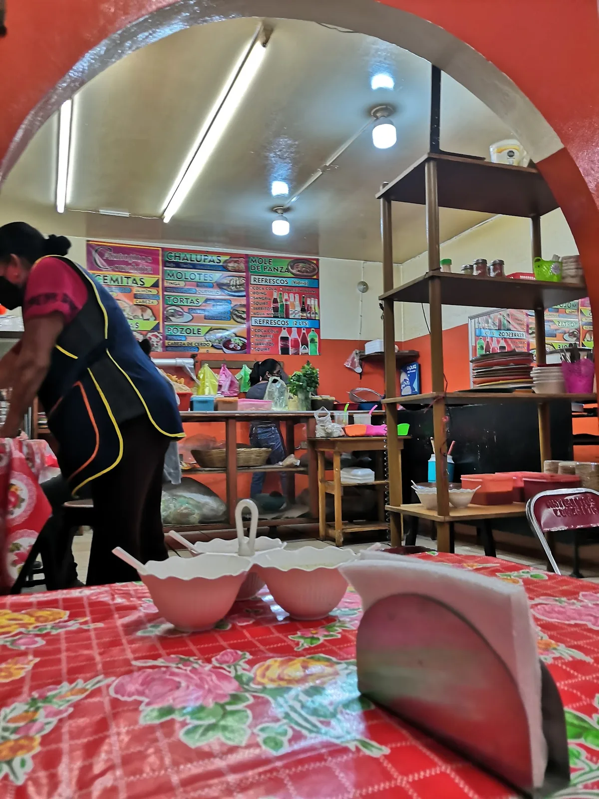Interior de la fonda: paredes naranjas y la lona con el menú